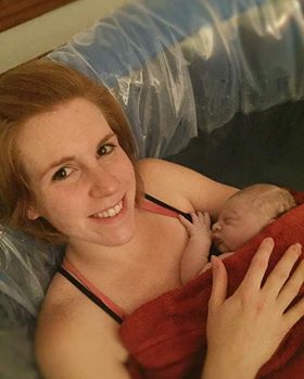 New mother and infant in birthing tub